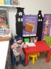Na zdjęciu mała czytelniczka, która siedzi przy stoliku w bibliotece. W dłoni trzyma książkę i kartę czytelnika.