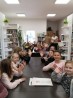 Dzieci siedzą przy stołach w bibliotece